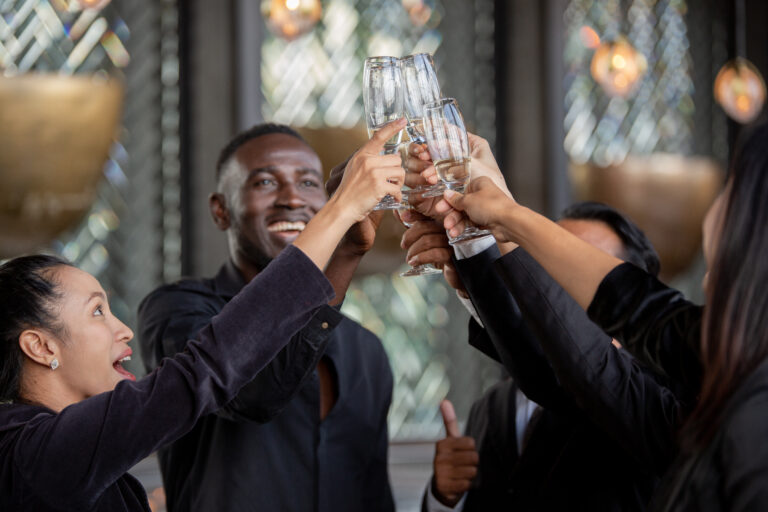 Group of diverse office people celebrating and toasting glasses of wine at the company meeting. Workers gathering and talking after work. Employees team enjoy New year event